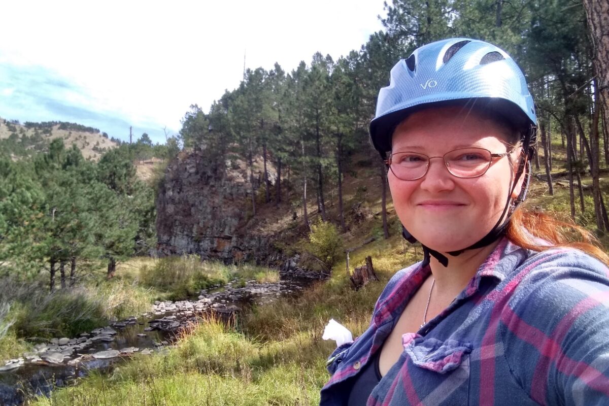 Woman with an equestrian helmet on on a trail ride in Custer State Park